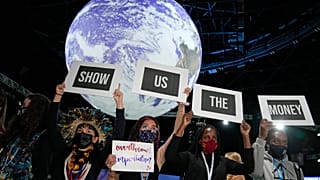 Climate activist Vanessa Nakate, second right, and other activists engage in a 'Show US The Money' protest at  COP26 in Glasgow, Scotland, Monday, Nov. 8, 2021. 