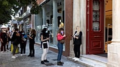 People line up so they can be checked for their Covid-19 vaccination certificates in order to be allowed to enter a shop in Athens, Greece, Saturday, Nov. 6, 2021.