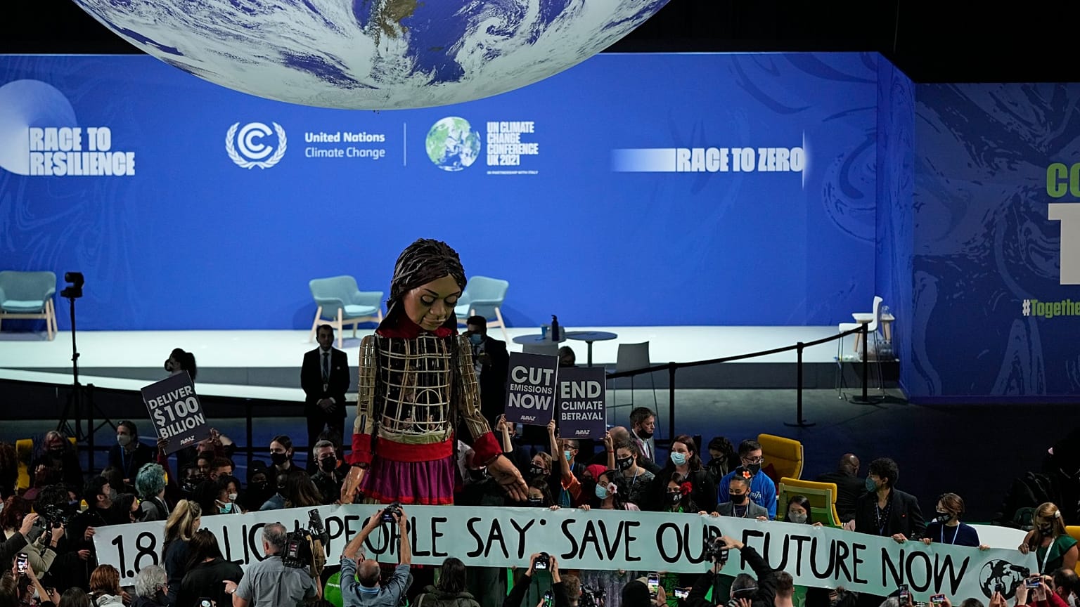 Giant puppet Little Amal walks through the Action Zone inside the venue of the COP26 UN Climate Summit in Glasgow, Scotland, Tuesday, Nov. 9, 2021.