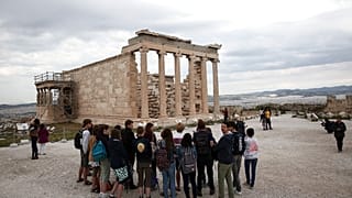 Des touristes devant le temple Erechtheion sur la colline de l'Acropole à Athènes