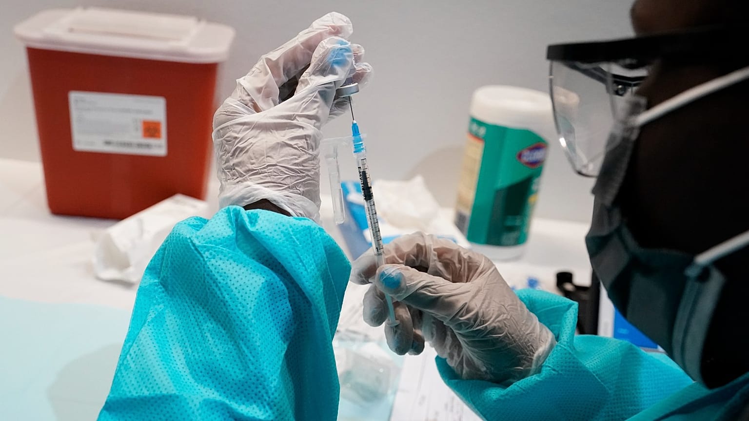 A health care worker fills a syringe with the Pfizer COVID-19 vaccine, at the American Museum of Natural History in New York.