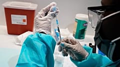 A health care worker fills a syringe with the Pfizer COVID-19 vaccine, at the American Museum of Natural History in New York.