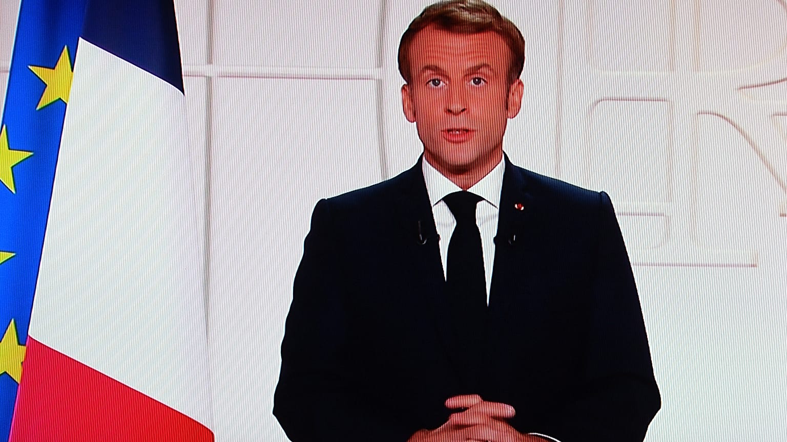 France's President Emmanuel Macron appears on a TV screen as he addresses to the nation on Covid-19 and reforms in Paris on November 9, 2021.