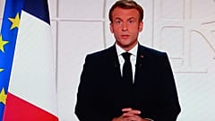 France's President Emmanuel Macron appears on a TV screen as he addresses to the nation on Covid-19 and reforms in Paris on November 9, 2021.