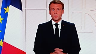 France's President Emmanuel Macron appears on a TV screen as he addresses to the nation on Covid-19 and reforms in Paris on November 9, 2021.