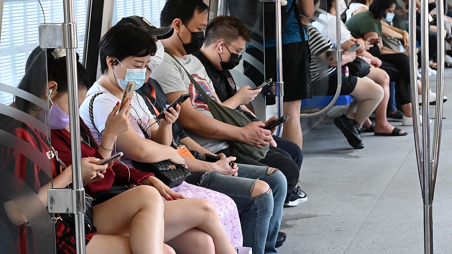 Menschen in einem Nahverkehrszug in Singapur 