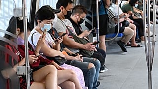 Menschen in einem Nahverkehrszug in Singapur