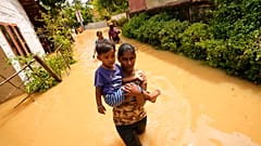 Une femme porte un enfant dans une rue inondée de Kochchikade, à 30 km de Colombo, Sri Lanka, le 10 novembre 2021