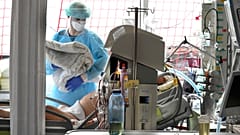 A nurse cares for a patient in the Covid 19 ward at Leipzig University Hospital in Germany.