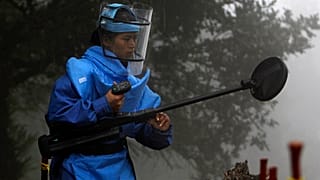 Una buscadora de minas comprueba el terreno en Nepal en una foto de archivo.