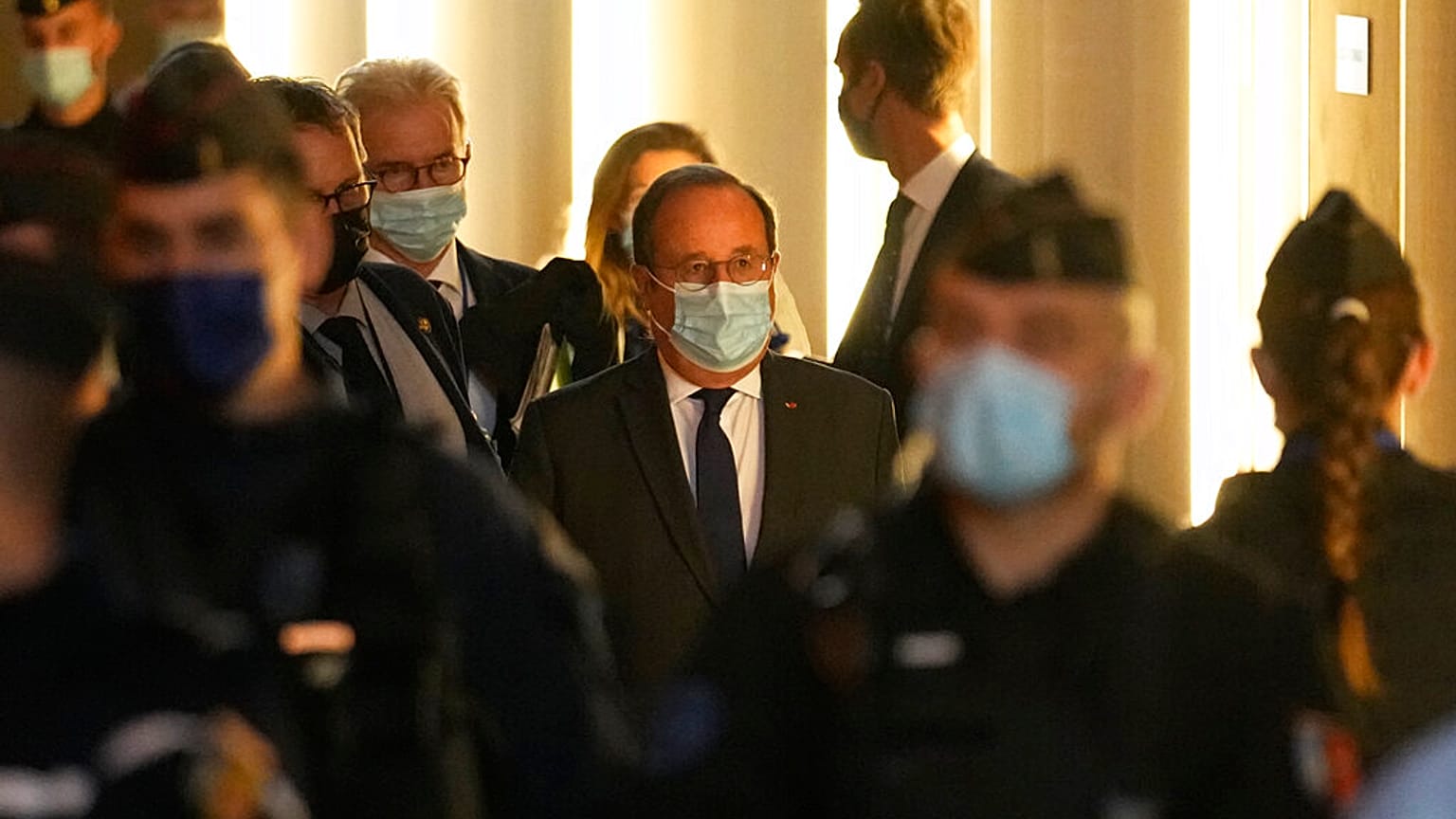 L'ancien président français François Hollande, au centre, arrive dans la salle d'audience spéciale pour témoigner dans le procès des attentats du 13 novembre 2015, 10/11/2021