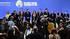 Ministers and representatives of the "Beyond Oil and Gas Alliance" pose on stage at the COP26