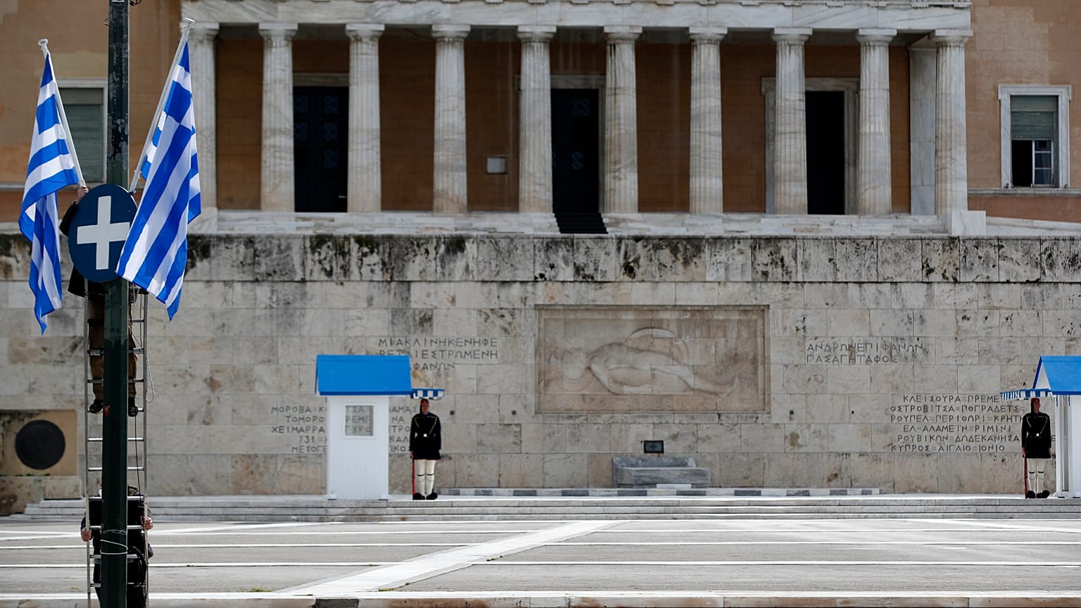 Municipal workers install Greek flags in front of the Greek parliament.