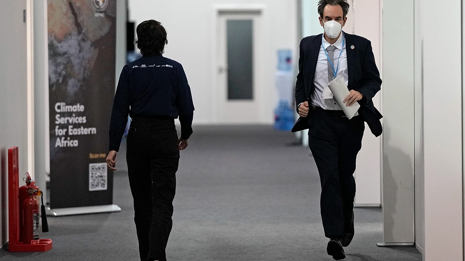 Luxembourg negotiator Andrew Ferrone runs inside the venue of the COP26 UN Climate Summit in Glasgow, Scotland, Friday, Nov. 12, 2021. 