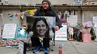 Richard Ratcliffe, husband of Nazanin Zaghari-Ratcliffe, holds up a picture of his wife as he continues his hunger strike outside Britain's Foreign Office on Nov. 11, 2021.