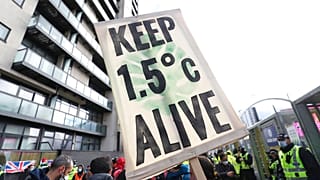 A placard reminds world leaders of their climate commitments at a COP26 demonstration in Glasgow on Friday