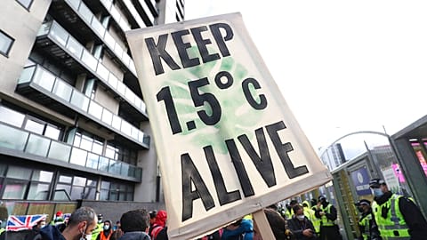 A placard reminds world leaders of their climate commitments at a COP26 demonstration in Glasgow on Friday