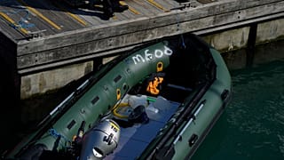 A dingy is moved from a British Border Force patrol boat in Dover harbour.