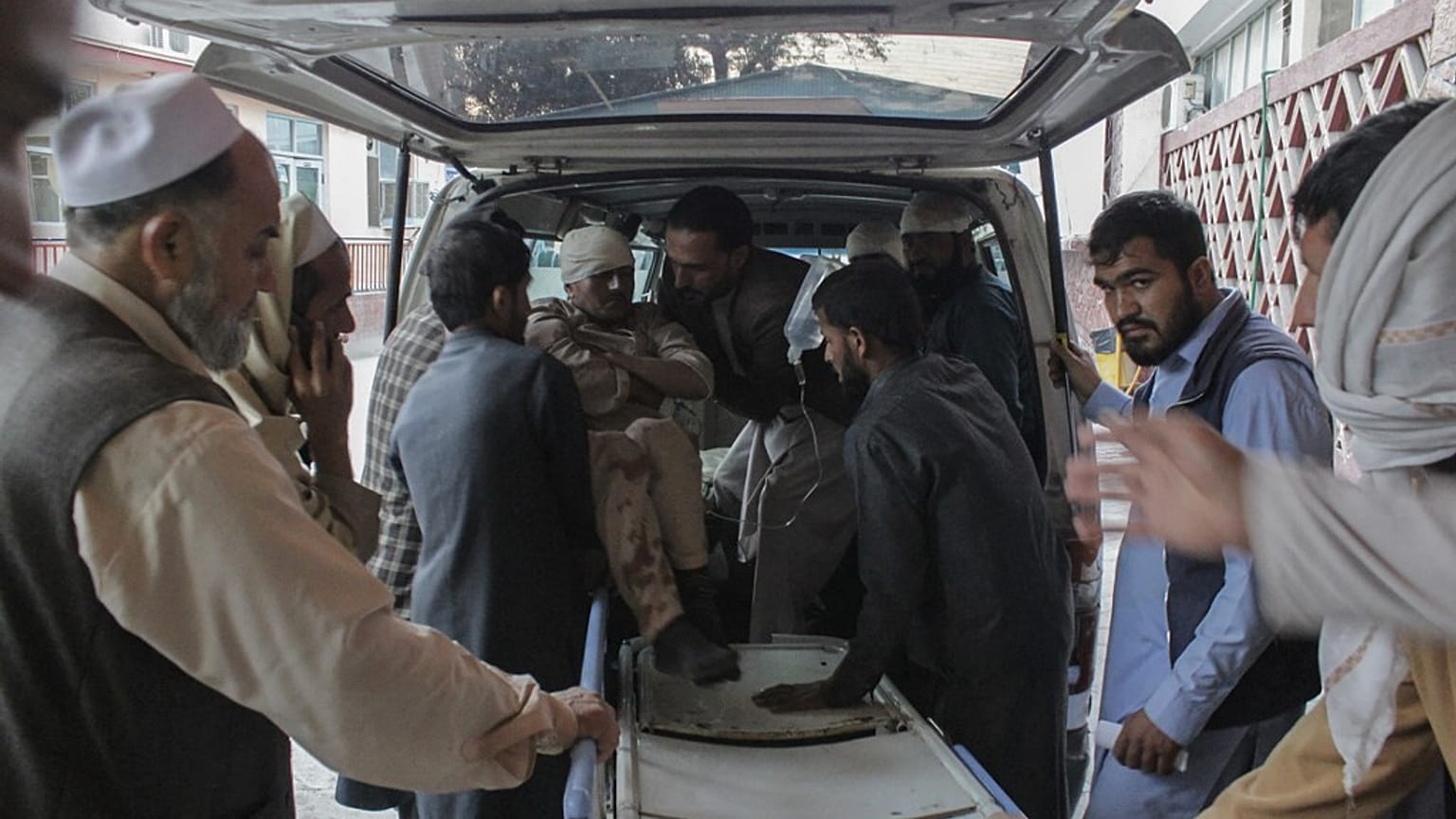 Afghan volunteers help place a wounded man on a stretcher at a hospital after the explosion.