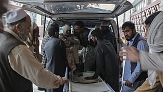Afghan volunteers help place a wounded man on a stretcher at a hospital after the explosion.