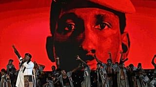 Ouagadougou (Burkina), ottobre 2021: il cantante senegalese Dier Awadi si esibisce sotto uno il ritratto di Thomas Sankara al 27° Pan African Film and Television Festival