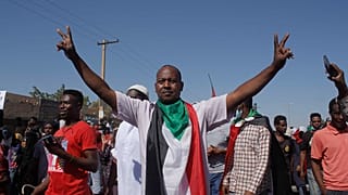 متظاهرون سودانيون مناهضون للانقلاب يلوحون بالعلم الوطني وهم يتجمعون في أحد شوارع العاصمة الخرطوم. 2021/11/13
