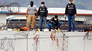 El cuerpo de un preso en el techo de la prisión de Guayaquil rodeado de fuerzas policiales