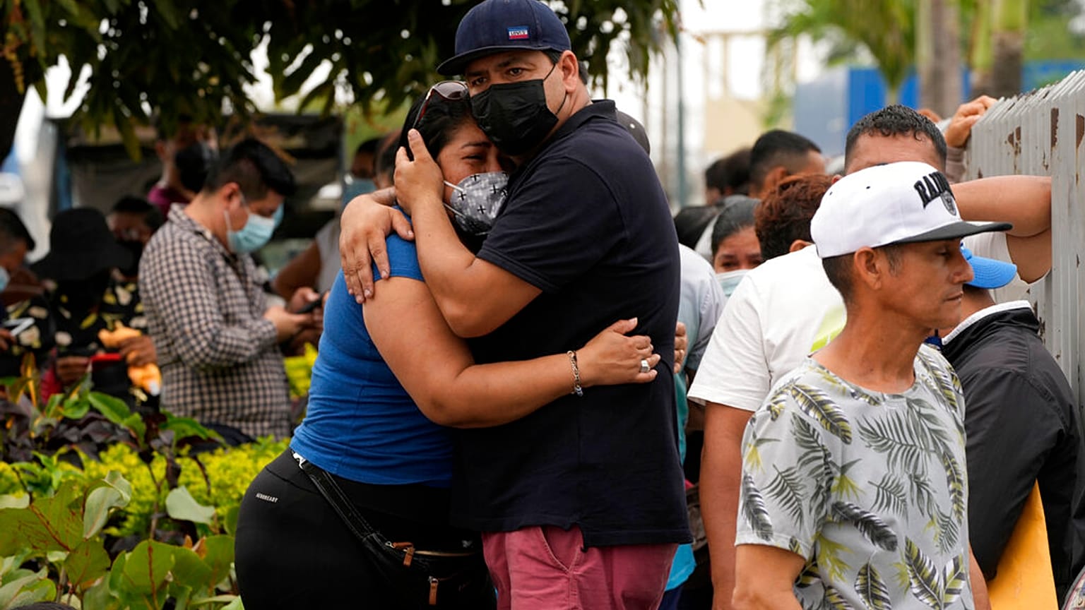 Des familles s’enlacent devant la morgue dans l'attente de nouvelles de leurs proches détenus au pénitencier de Guayaquil, en Équateur, dimanche 14 novembre 2021.