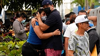 Des familles s’enlacent devant la morgue dans l'attente de nouvelles de leurs proches détenus au pénitencier de Guayaquil, en Équateur, dimanche 14 novembre 2021.