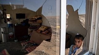 فتاة فلسطينية تظهر من نافذة منزل عائلتها المحطمة جراء هجوم مستوطنين، في قرية المفجرة قرب الخليل. 2021/09/30
