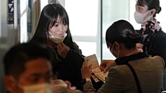 Japan's former Princess Mako, left, the elder daughter of Crown Prince Akishino, takes her mask off at a boarding gate to board an airplane to New York, 14 November 2021.