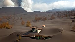 A house is covered by ash from a volcano as it continues to erupt on the Canary island of La Palma