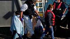 Мигранты сходят с патрульного катера британских пограничных войск в гавани Дувра