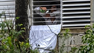 Yunior Garcia Aguilera protesta con una sábana blanca y rosas por su encierro en su vivenda