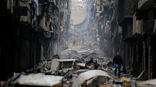 رجل يمشي خلال الدمار الذي لحق بحي صلاح الدين في حلب، سوريا.