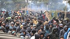 Migrants, sur le sol du Bélarus, se dirigant vers le poste frontière polonais de Kuznica, le 15 novembre 2021