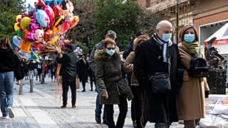 People make their way at a central market street in Athens, Sunday, Dec.19, 2021.