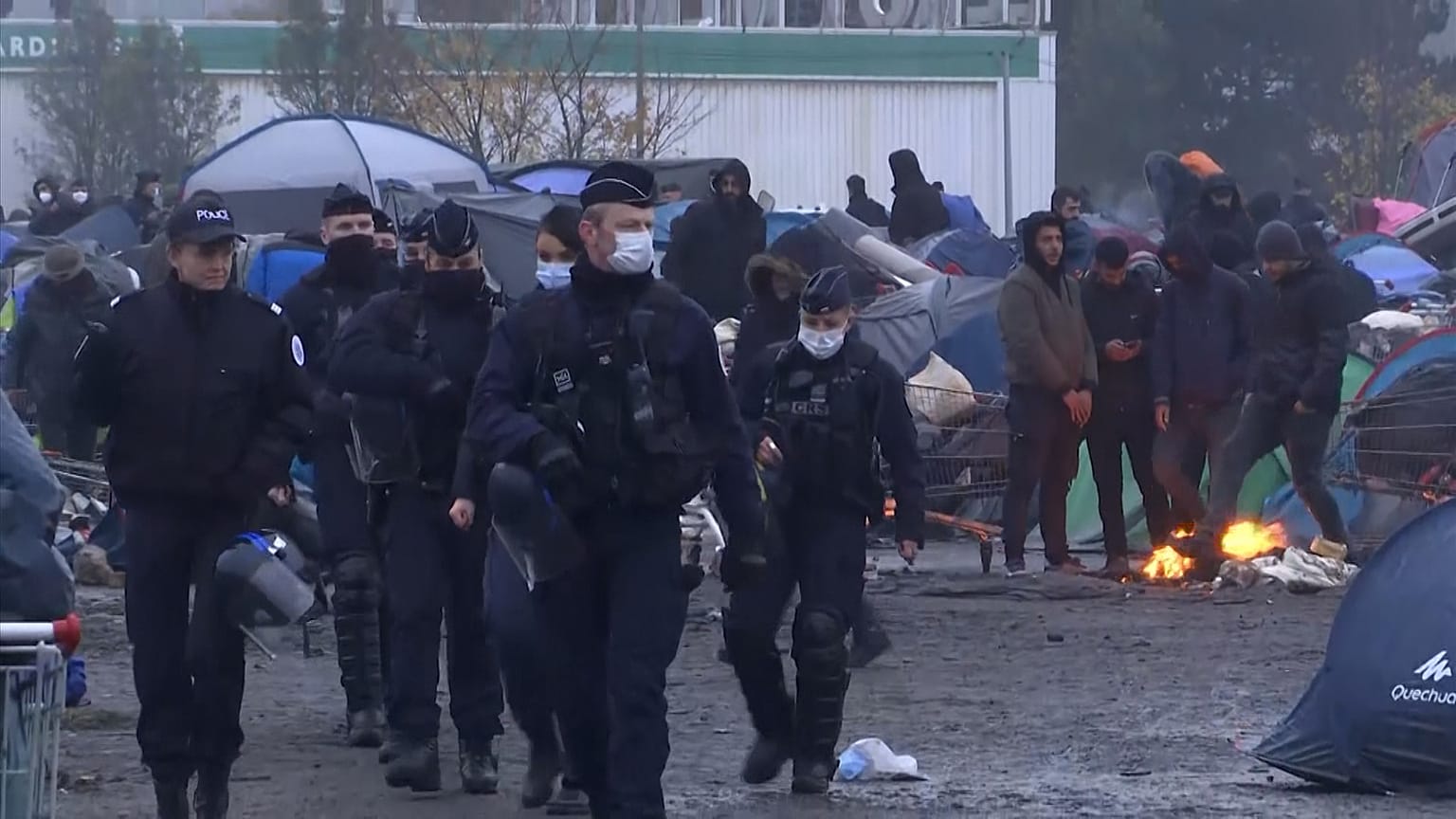 Police walking through camp near Grande-Synthe in northern France.