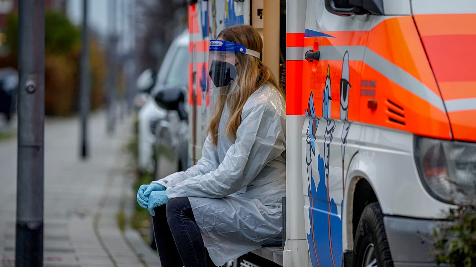 Almanya'nın Frankfurt kentinde bir seyyar Covid aracı içerisinde bir çocuğun test için hazırlanmasını bekleyen sağlık görevlisi