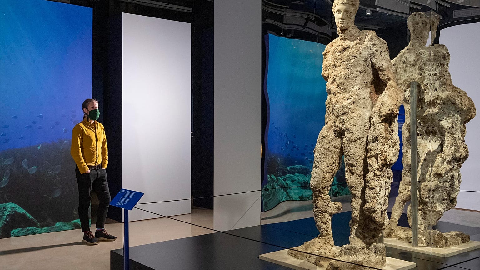 Visitor observes Hermes statue at new exhibition