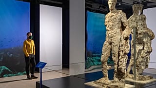 Visitor observes Hermes statue at new exhibition