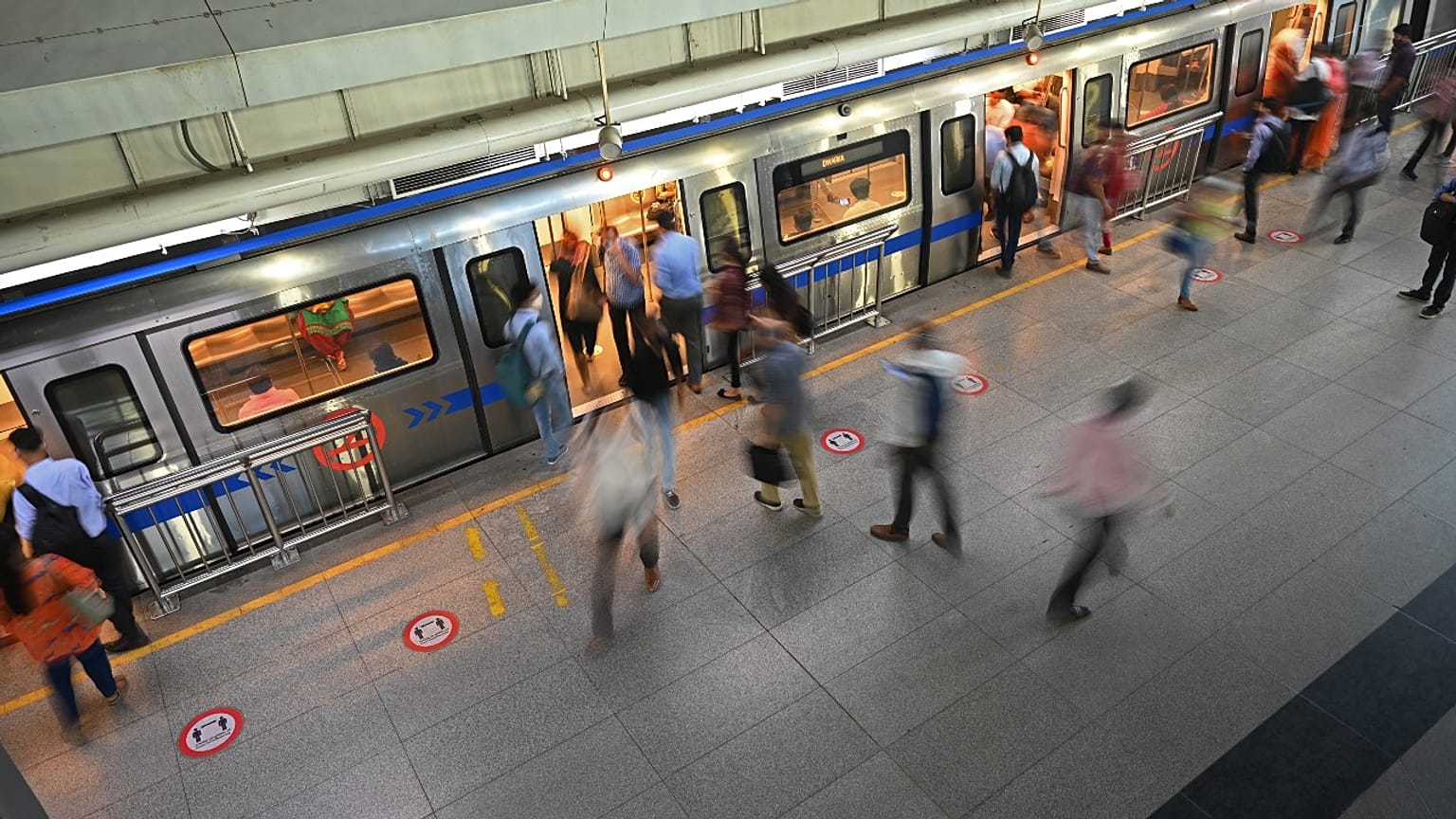 Commuters board the metro at a station after the services were allowed to operate at 50 percent capacity in New Delhi on June 7, 2021