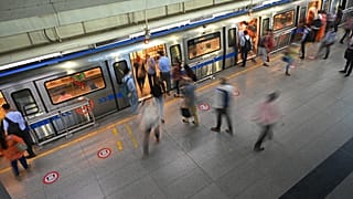 Commuters board the metro at a station after the services were allowed to operate at 50 percent capacity in New Delhi on June 7, 2021