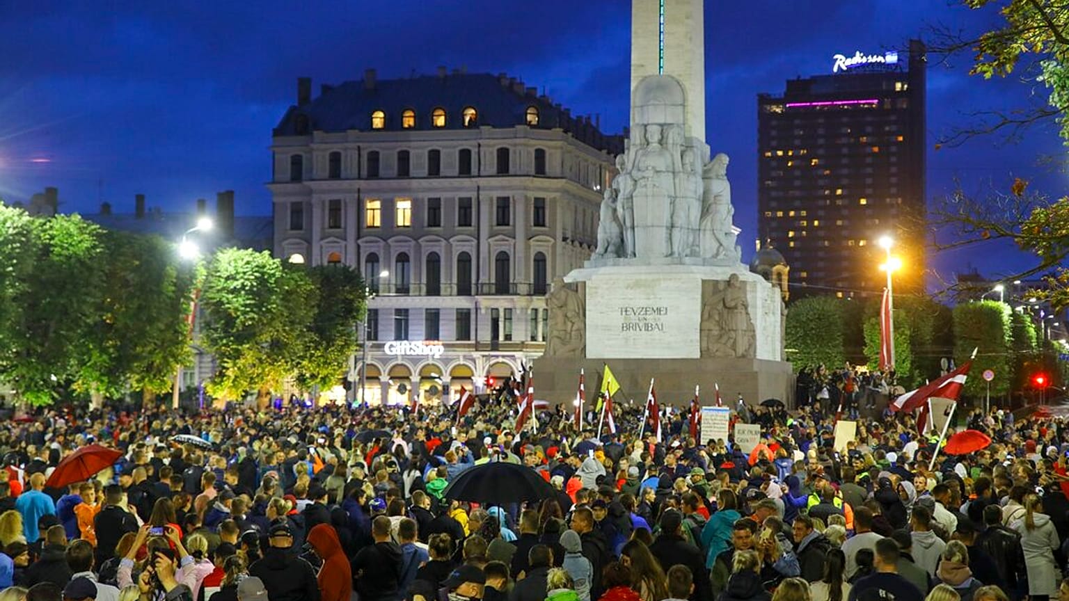 People gather around the Independence Stella monument at a protest against mandatory vaccinations in Riga, Latvia in August 2021 