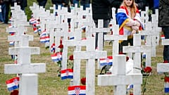 A little girl draped in the Croatian flag looks on at Vukovar's memorial cemerety, in Vukovar, eastern Croatia, Thursday, Nov. 18, 2021. 