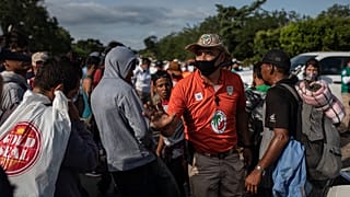Un funcionario de migración mexicano intenta persuadir a los migrantes para que no sigan caminando hacia el norte, 16/11/2021, Jesús Carranza, México