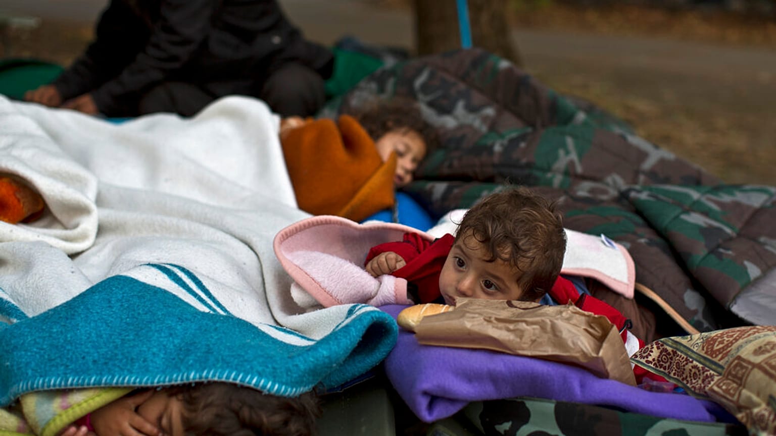 FILE: Yazidi refugee children from Mosul, Iraq, sleep with their family near an abandoned military barrack in Beli Manastir, northeast Croatia, Saturday, Sept. 19,2015. 