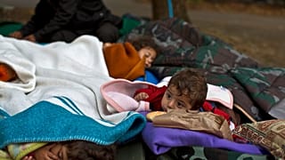 FILE: Yazidi refugee children from Mosul, Iraq, sleep with their family near an abandoned military barrack in Beli Manastir, northeast Croatia, Saturday, Sept. 19,2015. 