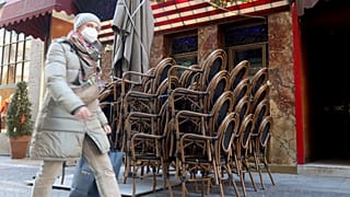 Una mujer camina por delante de un bar cerrado en el centro de Viena, Austria, el 15 de febrero de 2021. (ARCHIVO)