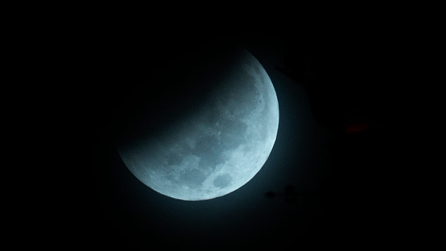 The Earth's shadow begins to fall on the moon during a total lunar eclipse, as seen above Miami, Wednesday, Oct. 8, 2014